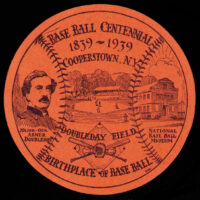 Die-cut round sticker slightly larger than a baseball at 3 1/2" diameter (a baseball is under 3"); black on orange-coated paper; unknown initials A.R.C. at lower right.